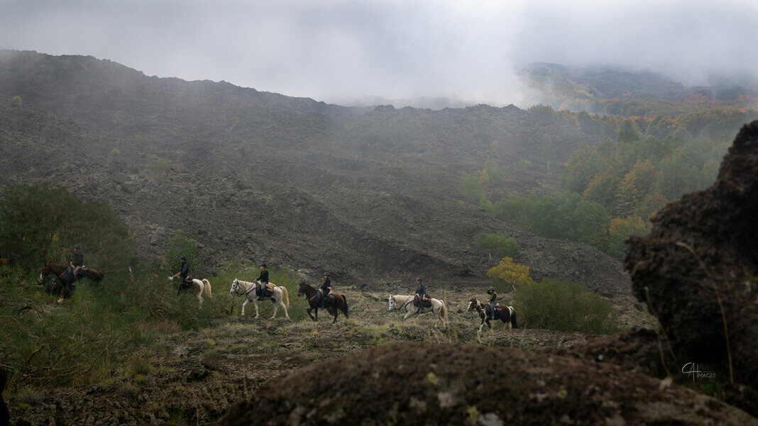 Reiter durchqueren trockenes, hügeliges Gelände im Madonie Nationalpark.