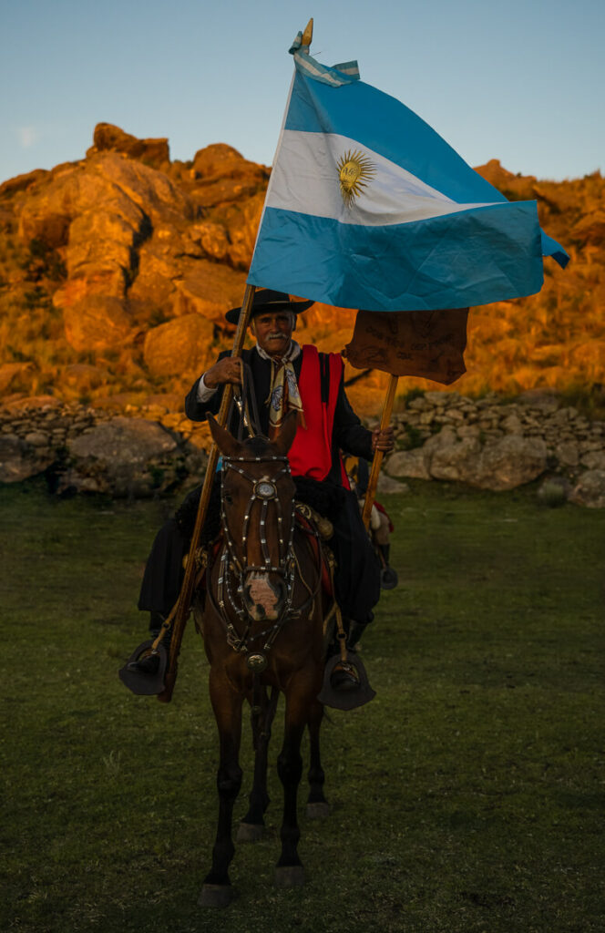 Der älteste Gaucho (78) des Festivals auf seinem Pferd mit einer großen, wehenden Argentinien-Flagge in der Hand.